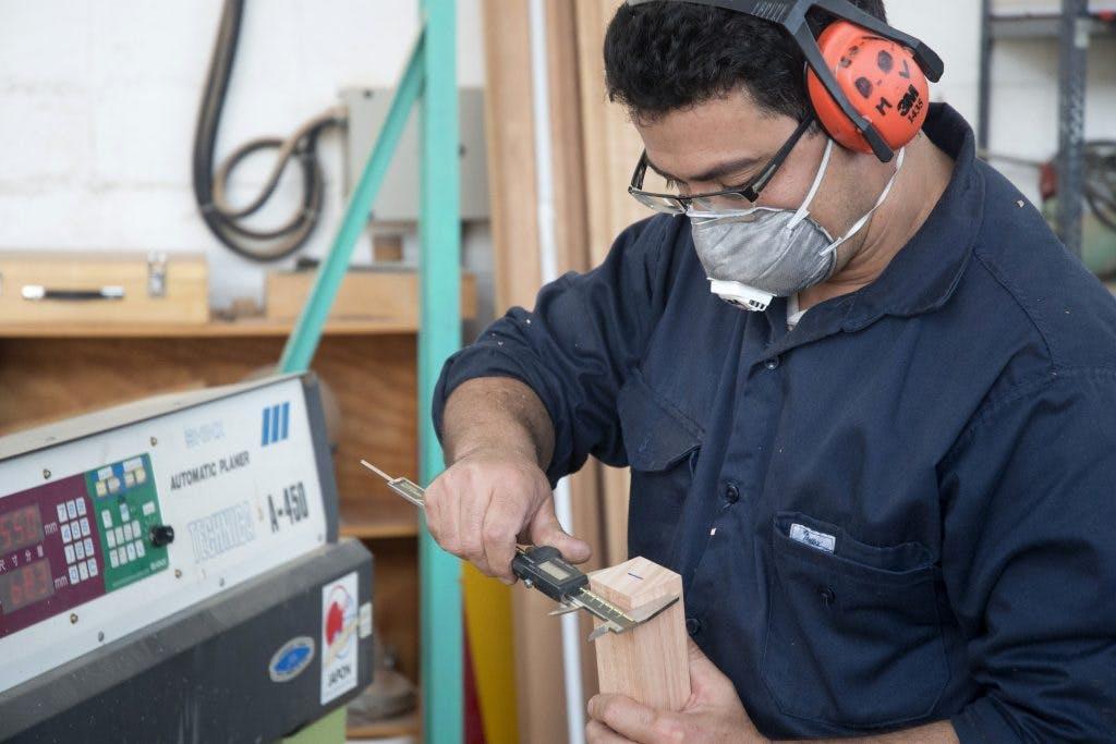 Analista del LATU trabaja con madera, usando equipamiento de seguridad